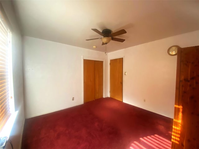 unfurnished room featuring ceiling fan and carpet