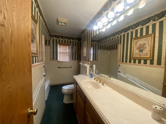 bathroom featuring tile walls, toilet, and vanity