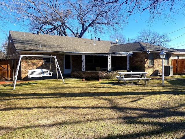 back of property with a lawn and cooling unit