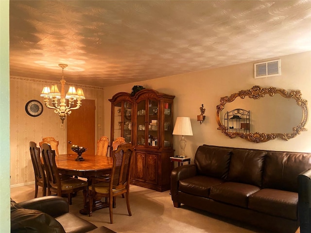 carpeted dining space with an inviting chandelier and a textured ceiling