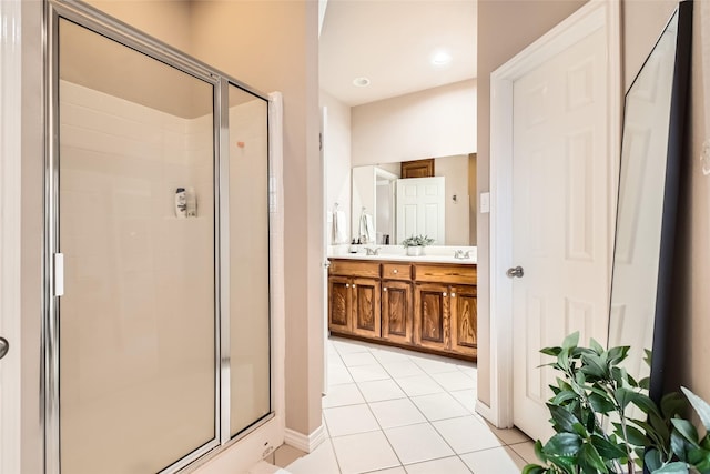 bathroom with tile patterned flooring, vanity, and walk in shower