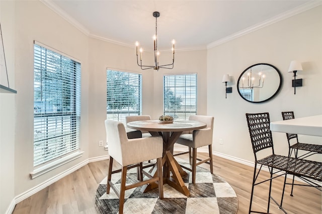 dining space featuring crown molding, an inviting chandelier, and light hardwood / wood-style flooring