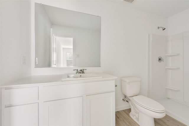 bathroom featuring toilet, a shower, wood-type flooring, and vanity