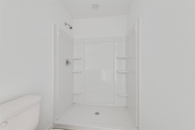 bathroom with toilet and walk in shower