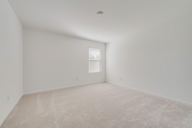 spare room featuring light colored carpet