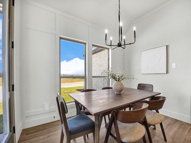 dining room featuring dark hardwood / wood-style flooring, ornamental molding, and a notable chandelier