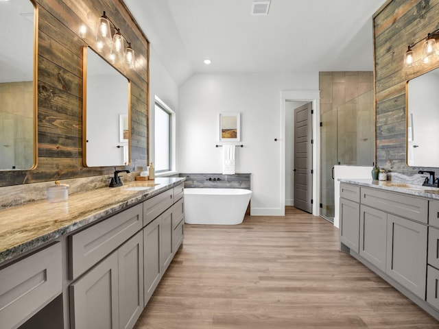 bathroom with wood-type flooring, plus walk in shower, lofted ceiling, and vanity