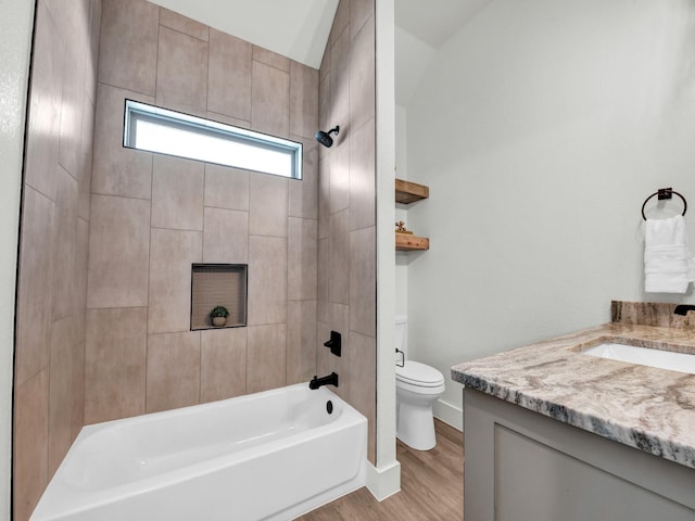 full bathroom with tiled shower / bath combo, hardwood / wood-style floors, toilet, and vanity