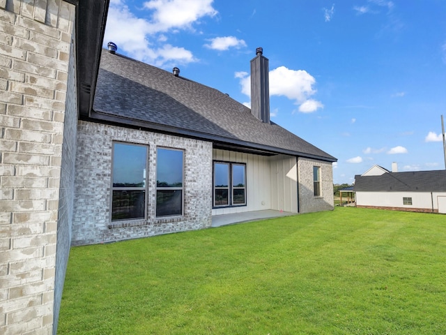 rear view of property featuring a lawn