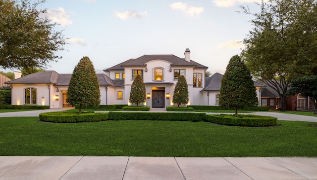 french country style house featuring a front lawn