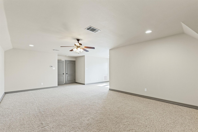 spare room featuring ceiling fan, light carpet, and vaulted ceiling