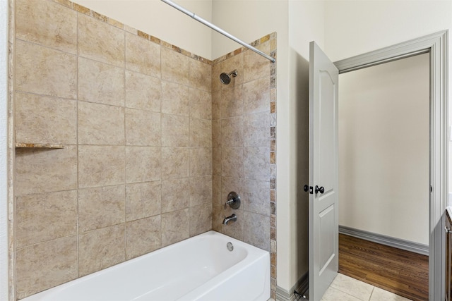 bathroom with tiled shower / bath and tile patterned flooring