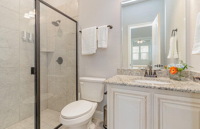 bathroom featuring a shower with shower door, toilet, and vanity