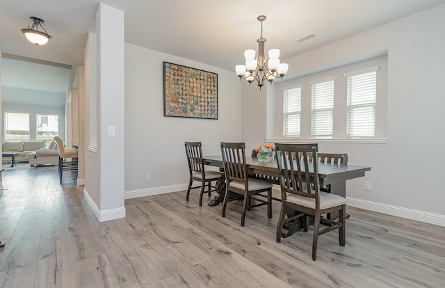 dining space featuring a chandelier and light hardwood / wood-style flooring