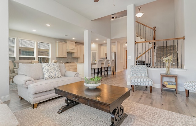 living room with ceiling fan and light hardwood / wood-style flooring