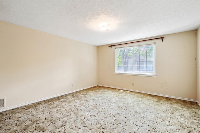 spare room featuring a textured ceiling and carpet flooring