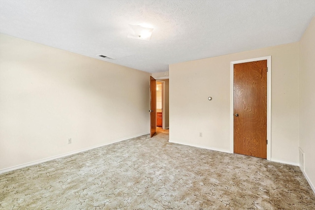 carpeted empty room with a textured ceiling