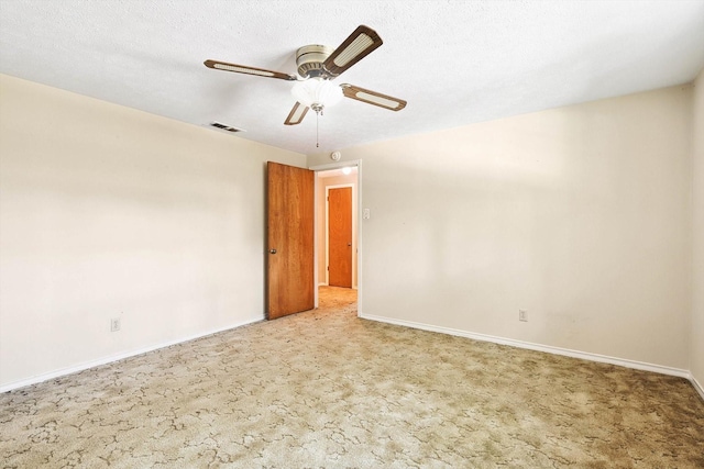 carpeted empty room with ceiling fan and a textured ceiling