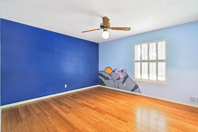 unfurnished room with ceiling fan, hardwood / wood-style floors, and a textured ceiling