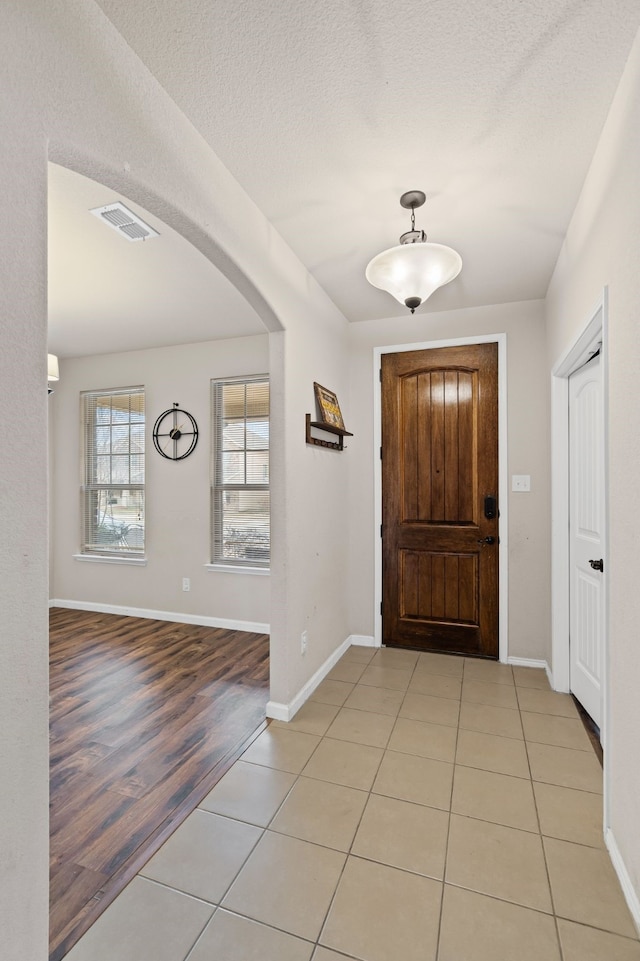 tiled foyer entrance with a textured ceiling