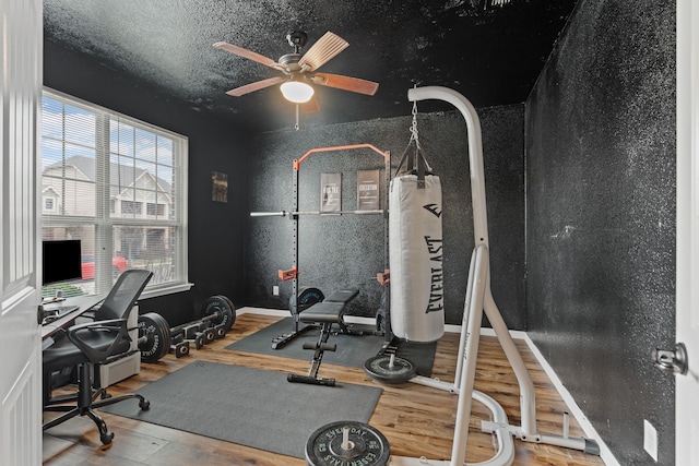 workout area with wood-type flooring, ceiling fan, and a textured ceiling