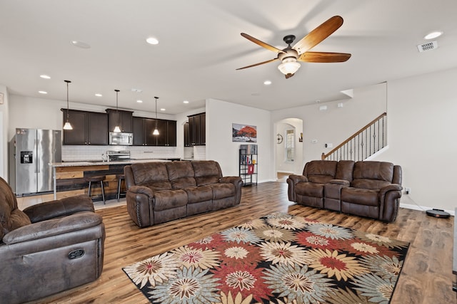 living room with ceiling fan and light wood-type flooring