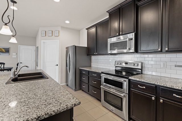 kitchen with appliances with stainless steel finishes, pendant lighting, sink, backsplash, and dark brown cabinets