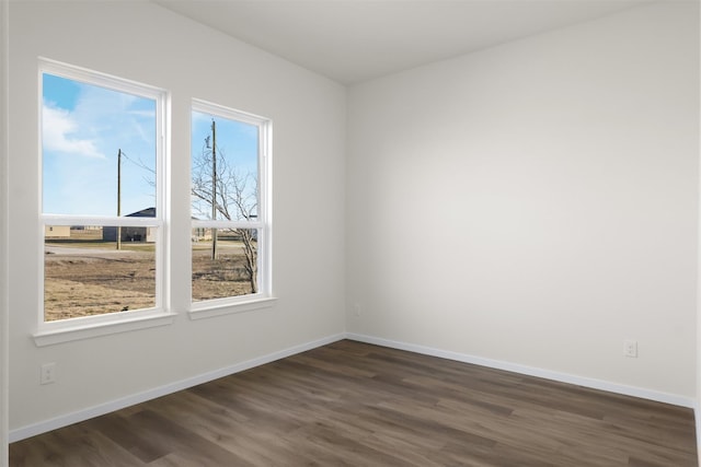 empty room featuring dark hardwood / wood-style flooring and a wealth of natural light