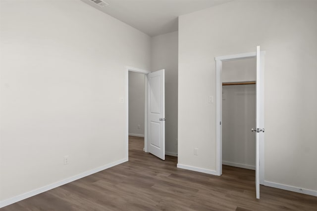 unfurnished bedroom with a closet and dark hardwood / wood-style floors