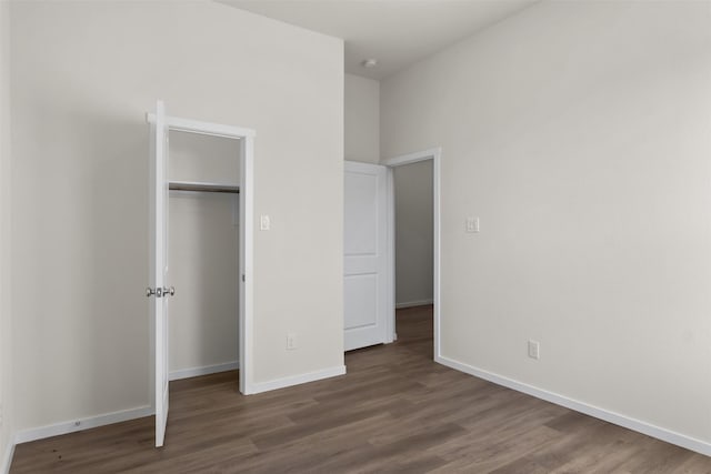 unfurnished bedroom featuring dark hardwood / wood-style floors and a closet