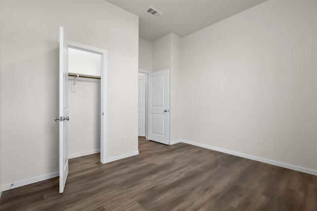 unfurnished bedroom with a closet and dark hardwood / wood-style flooring