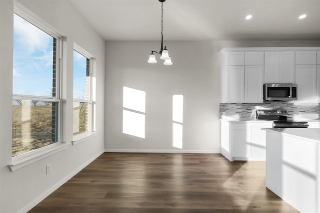 kitchen featuring white cabinetry, electric range, decorative backsplash, and pendant lighting