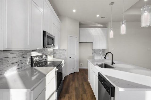 kitchen featuring decorative light fixtures, sink, light stone countertops, appliances with stainless steel finishes, and white cabinets