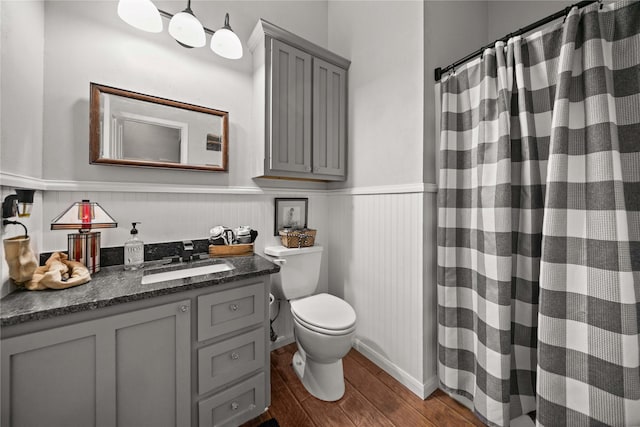 bathroom featuring toilet, vanity, and curtained shower