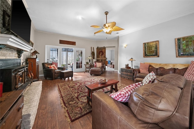 living room with ceiling fan, wood-type flooring, crown molding, and a barn door