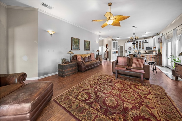 living room featuring ceiling fan with notable chandelier, dark hardwood / wood-style flooring, and ornamental molding