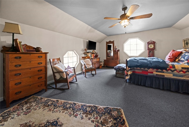 bedroom with ceiling fan, dark carpet, and vaulted ceiling