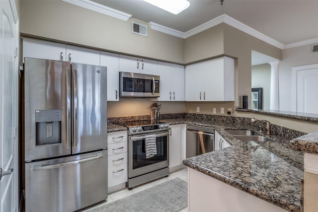 kitchen featuring kitchen peninsula, white cabinetry, appliances with stainless steel finishes, and ornamental molding