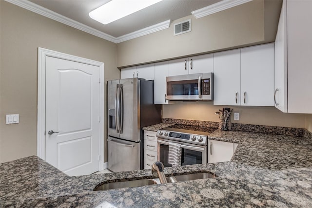 kitchen with dark stone countertops, sink, stainless steel appliances, ornamental molding, and white cabinets