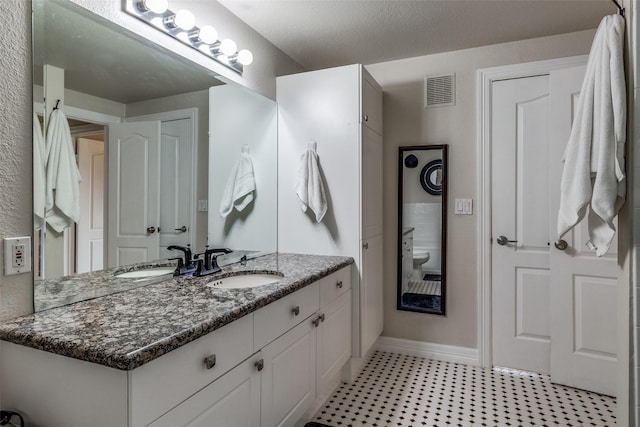 bathroom with a textured ceiling and vanity