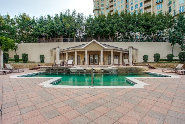 view of pool with pool water feature and a patio