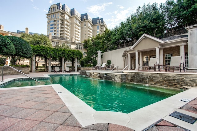 view of pool with pool water feature and a patio