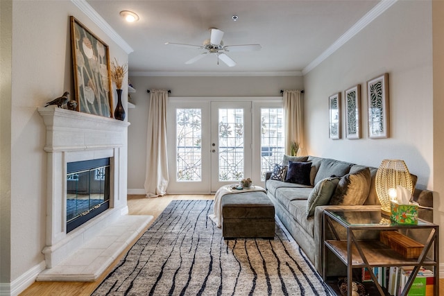 living room with a tile fireplace, crown molding, and light hardwood / wood-style flooring