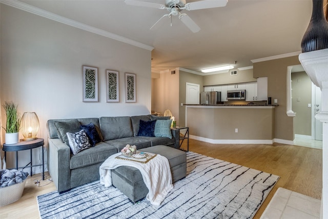 living room with ceiling fan, light wood-type flooring, and ornamental molding