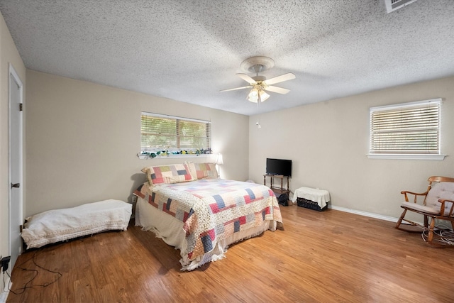 bedroom featuring a textured ceiling, ceiling fan, and hardwood / wood-style floors