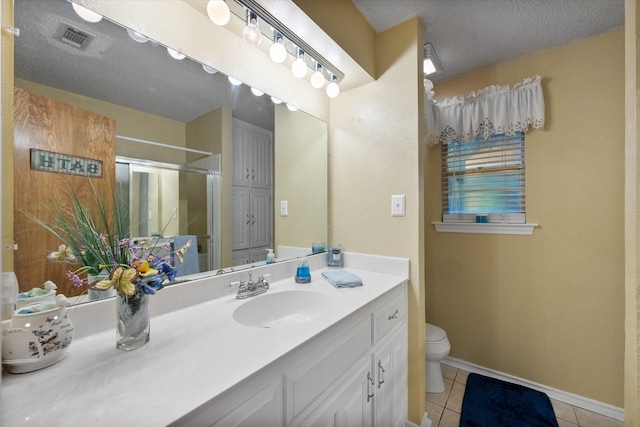 bathroom with toilet, a shower with shower door, tile patterned floors, a textured ceiling, and vanity