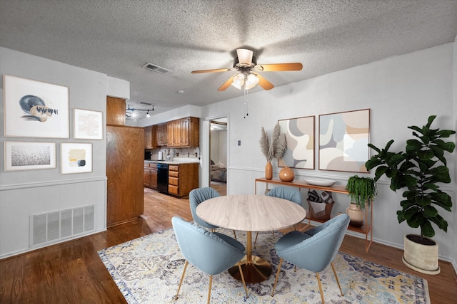 dining room with hardwood / wood-style flooring, a textured ceiling, and ceiling fan