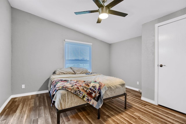 bedroom with ceiling fan, wood-type flooring, and lofted ceiling