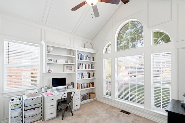 carpeted office space featuring vaulted ceiling, ceiling fan, and built in features