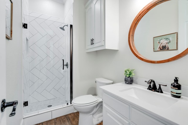 bathroom with toilet, hardwood / wood-style floors, an enclosed shower, and vanity